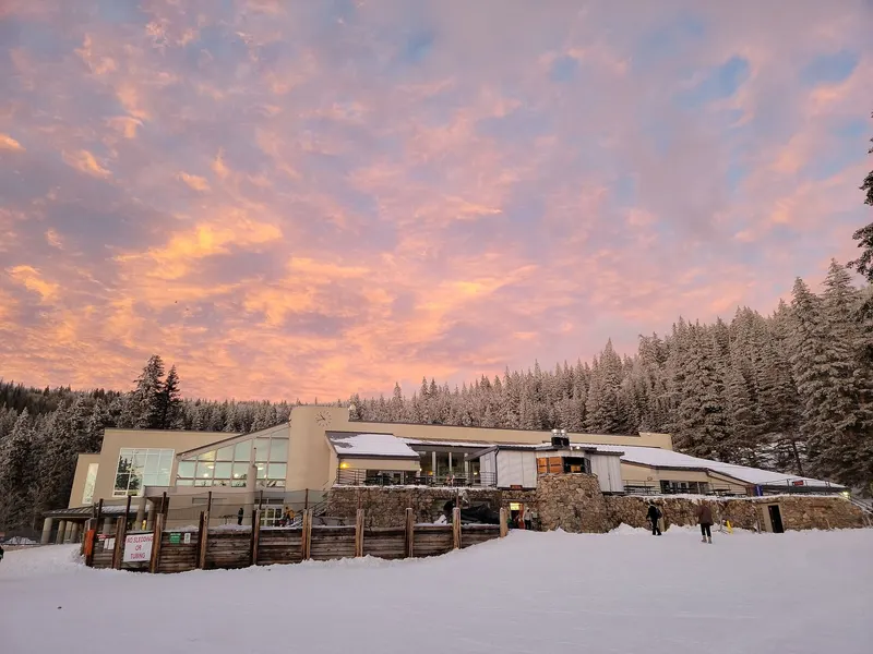 The Ski Santa Fe base lodge beneath a colorful evening sky with snow-covered trees